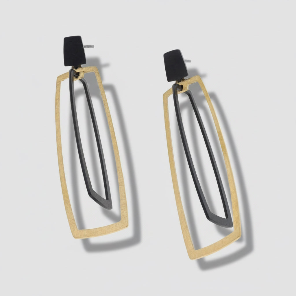 A pair of gold vermeil and silver kinetic drop earrings with a geometric design, displayed against a white background.