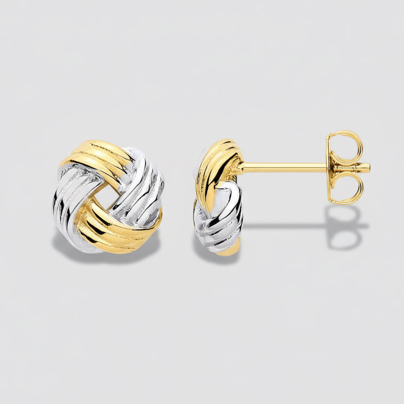 Pair of gold and silver knot earrings on a white background