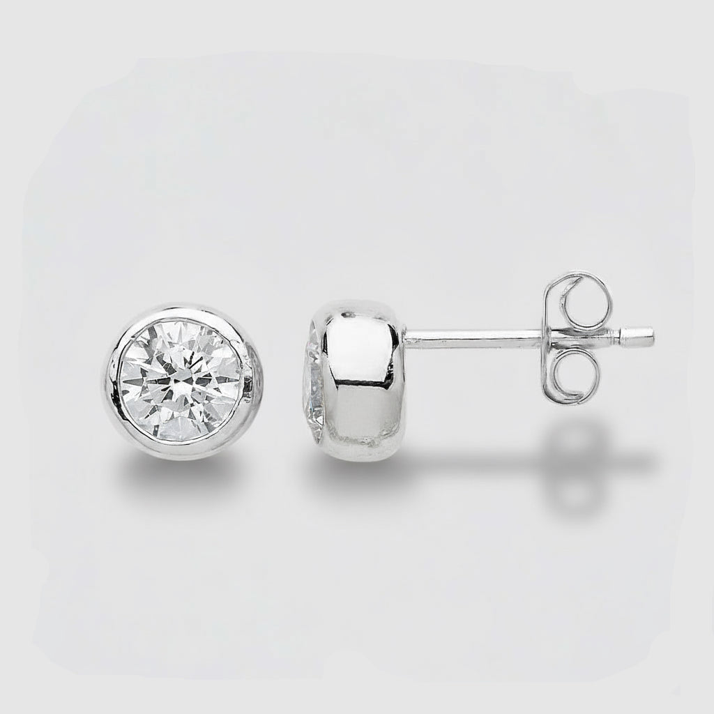 Gold stud earrings with clear gemstones on a light gray background