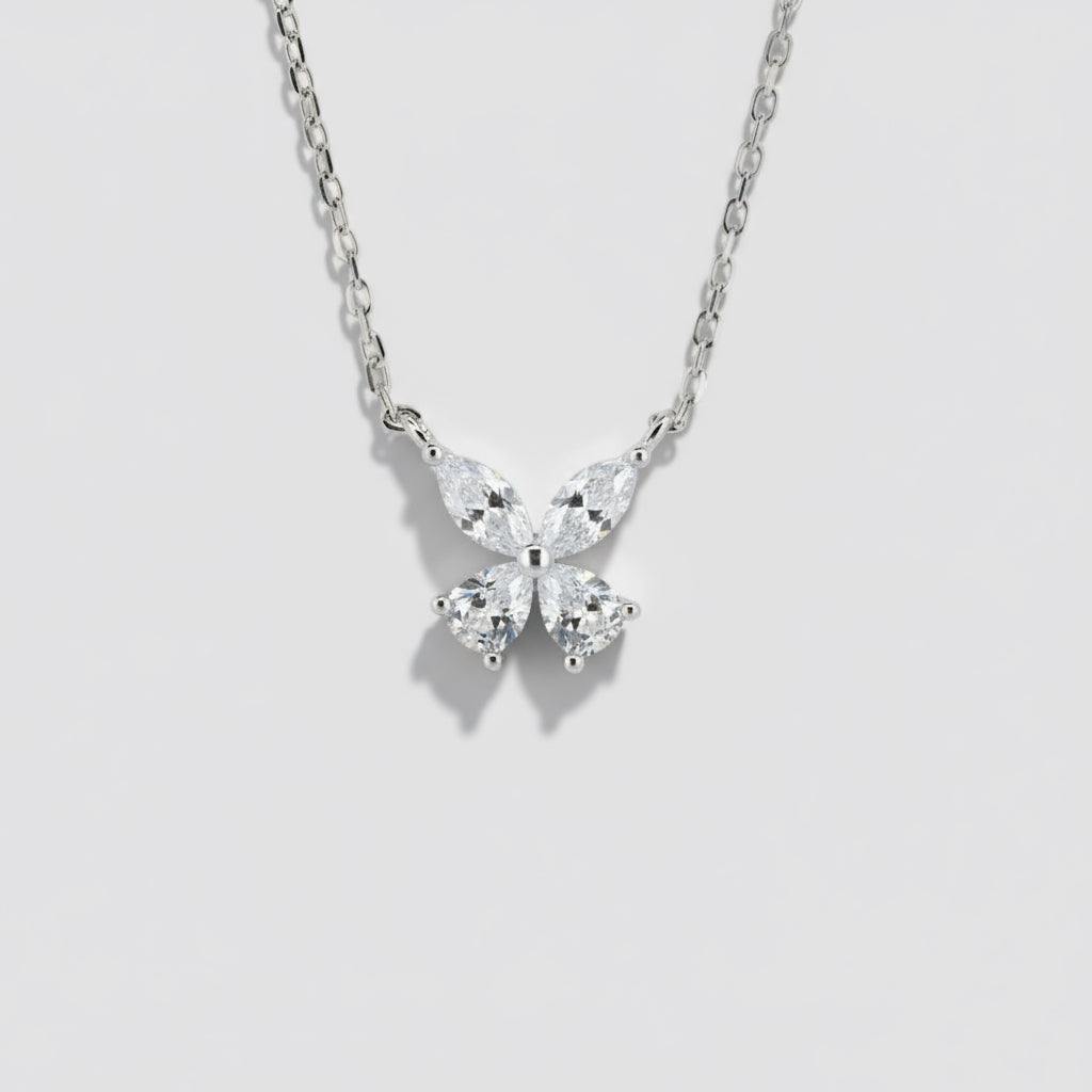 Butterfly-shaped diamond pendant on a chain against a white background