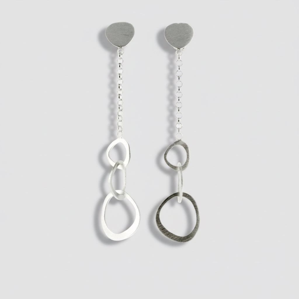 A pair of silver chain drop earrings with a pebbly texture, displayed against a white background.
