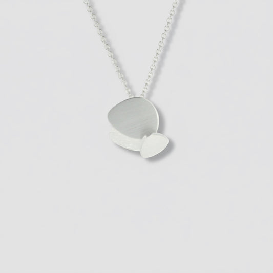 A sterling silver geometric pendant necklace with a silver chain and a layered circular pendant