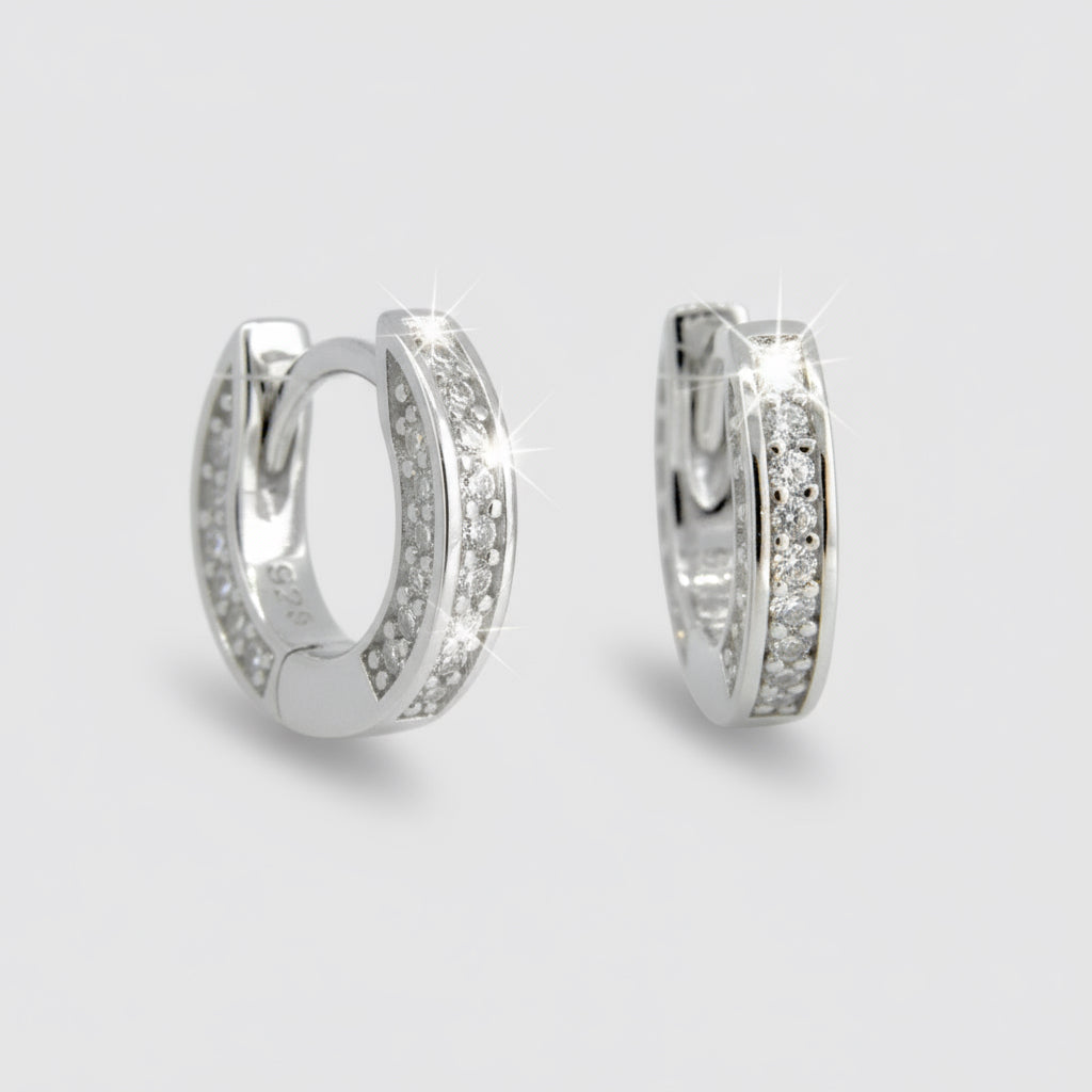 A pair of silver hoop earrings with cubic zirconia accents.