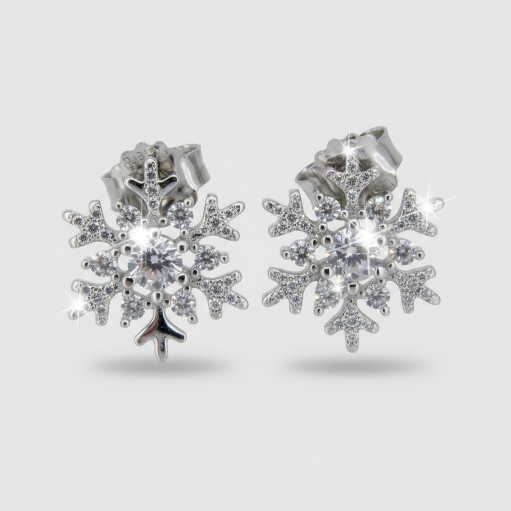 A pair of silver rhodium-plated sterling silver earrings with cubic zirconia embellishments in the shape of snowflakes.