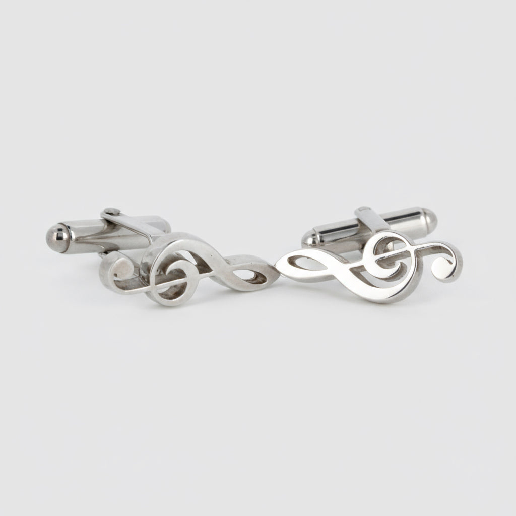 Pair of silver treble clef cufflinks on a light gray background