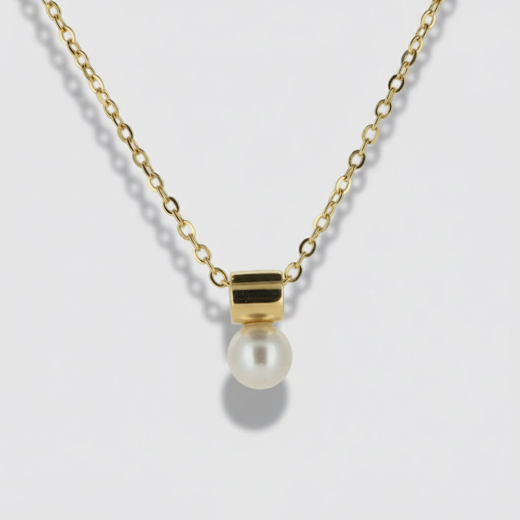 Gold necklace with a pearl pendant on a light gray background