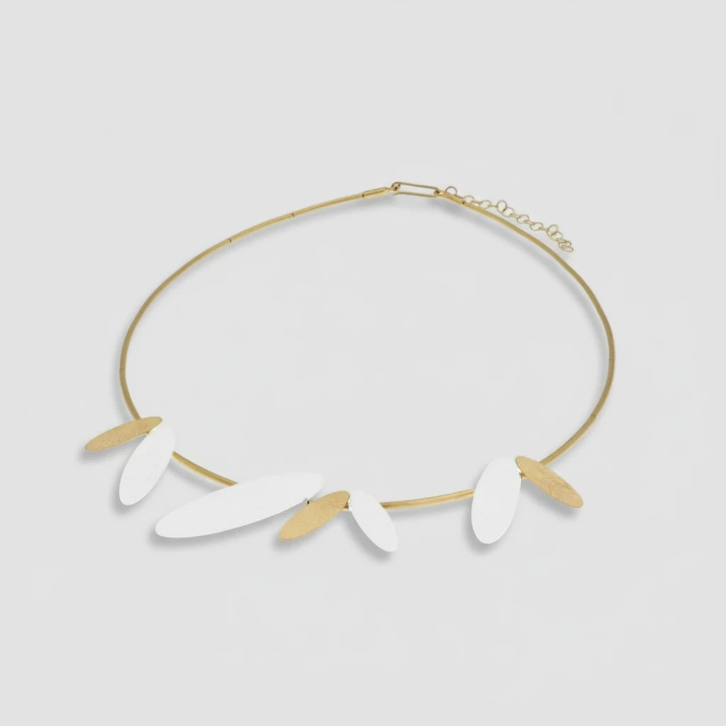 Gold necklace with white leaf-like pendants on a white background.