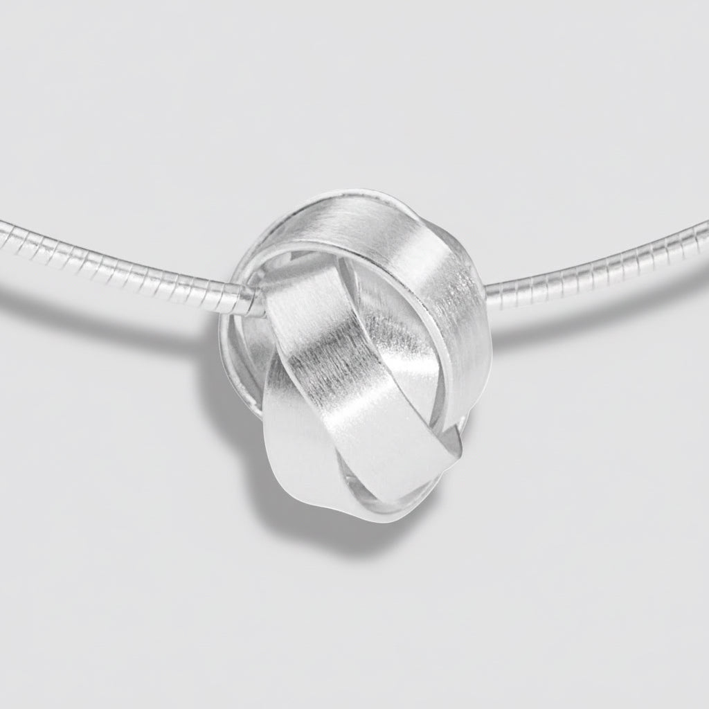 Silver interlocking ring charm on a white background
