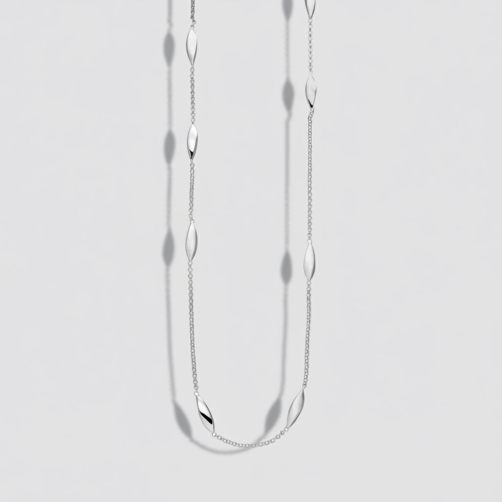 Silver necklace with small oval pendants on a white background