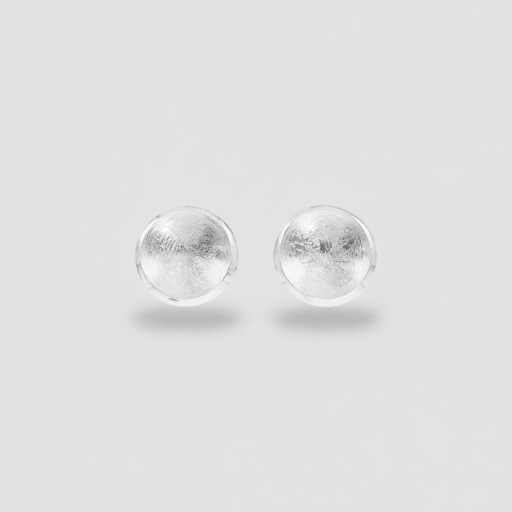 Pair of silver round earrings on a white background