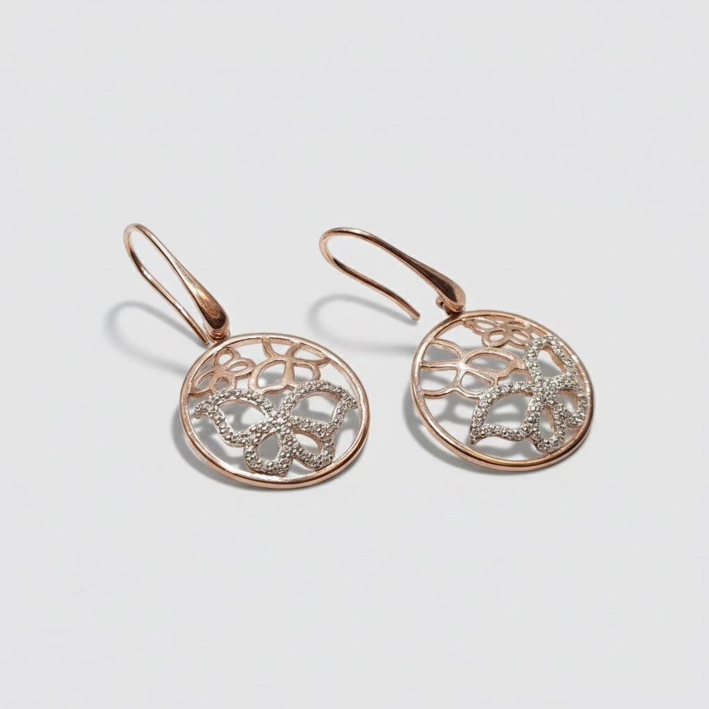 Rose gold earrings with intricate designs on a white background