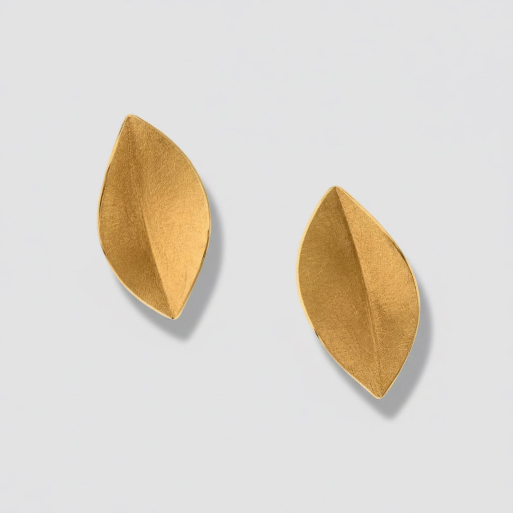 Pair of gold leaf-shaped earrings on a white background