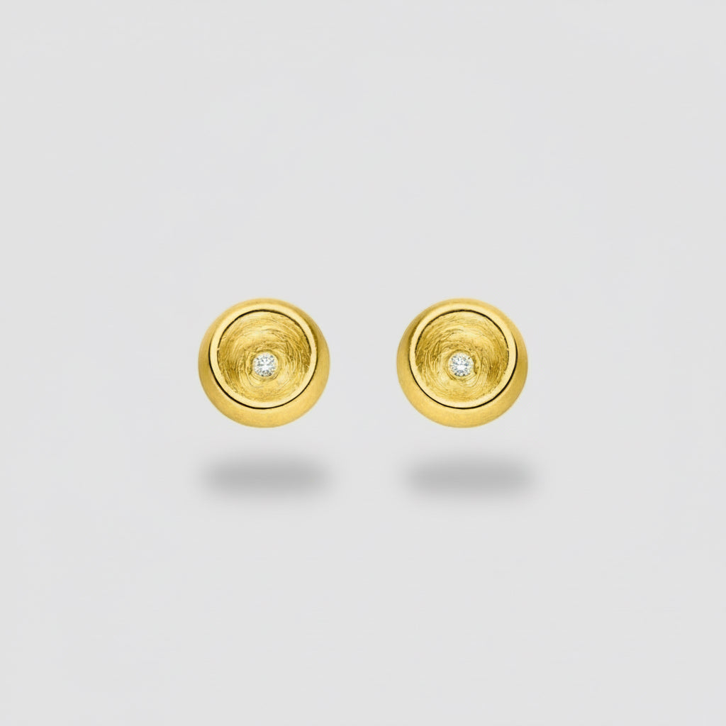 Gold circular earrings with embedded diamonds on a white background