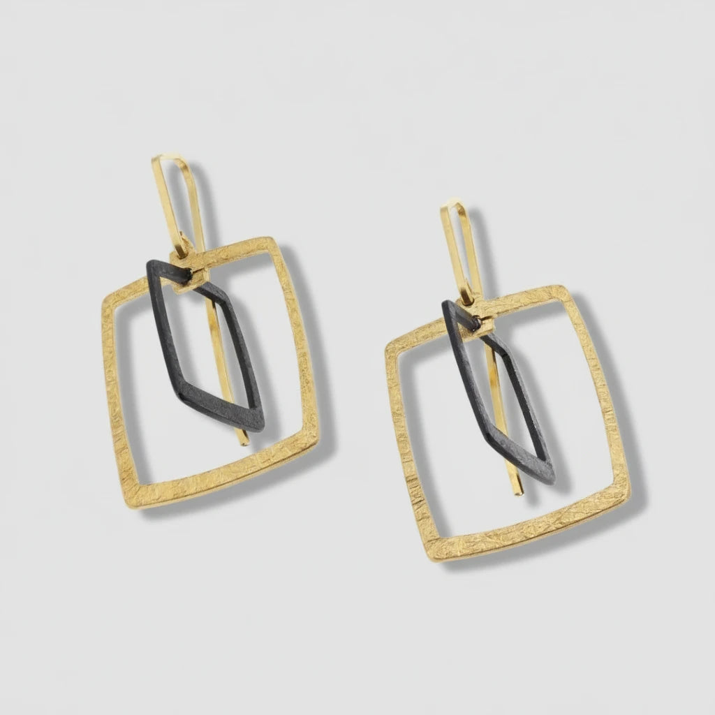 Pair of gold and black square-shaped earrings on a white background