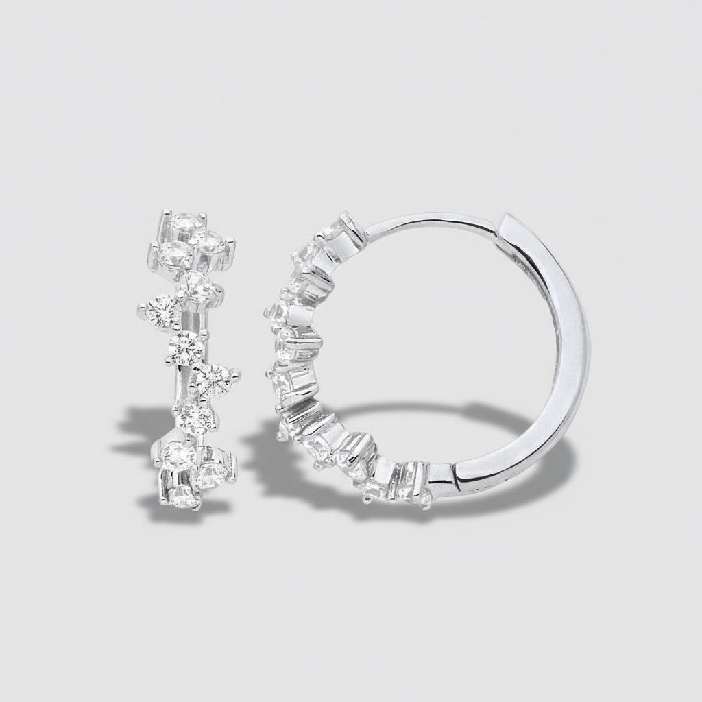 Pair of silver hoop earrings with clear gemstones on a white background