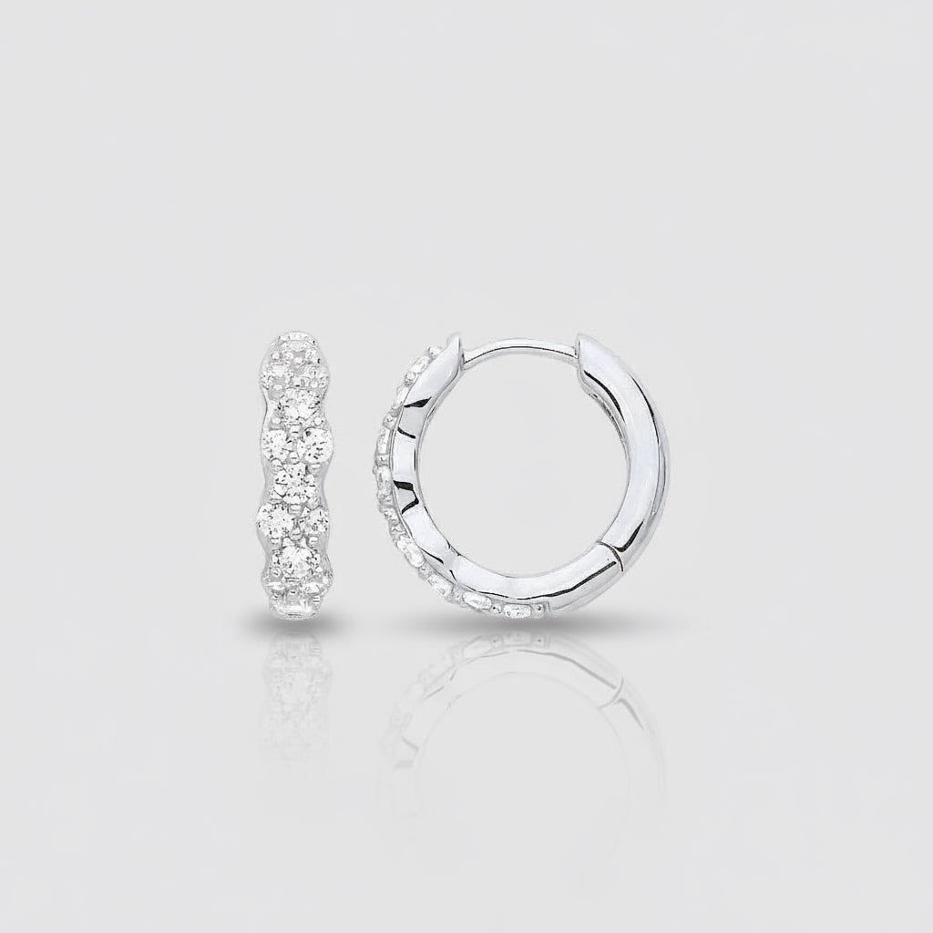 Silver hoop earrings with clear gemstones on a white background