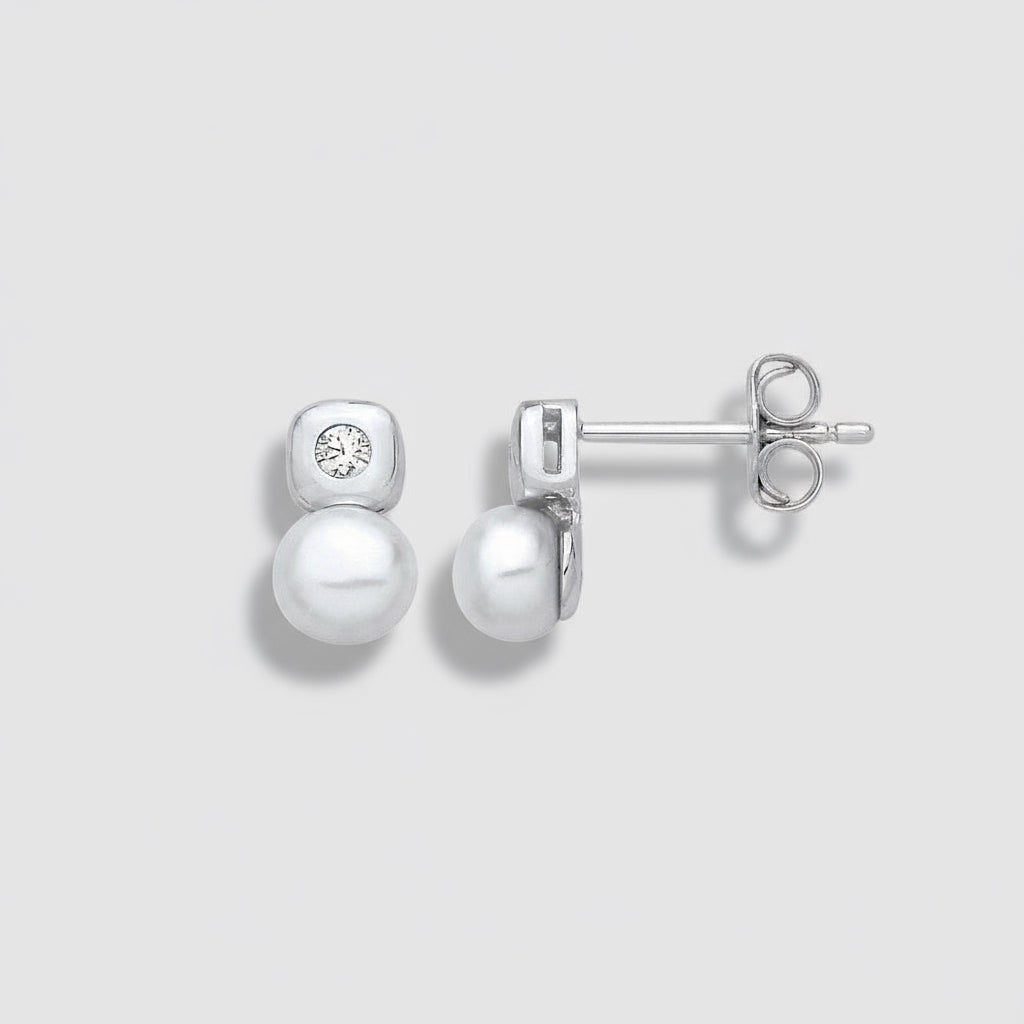 Pearl earrings with silver posts on a light gray background