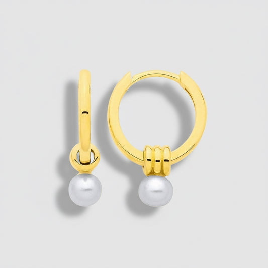 Gold hoop earrings with pearls on a light gray background