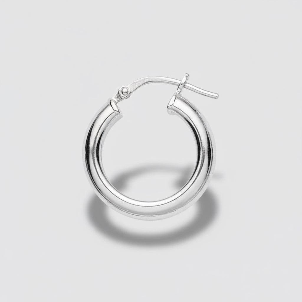 Gold hoop earring on a light gray background