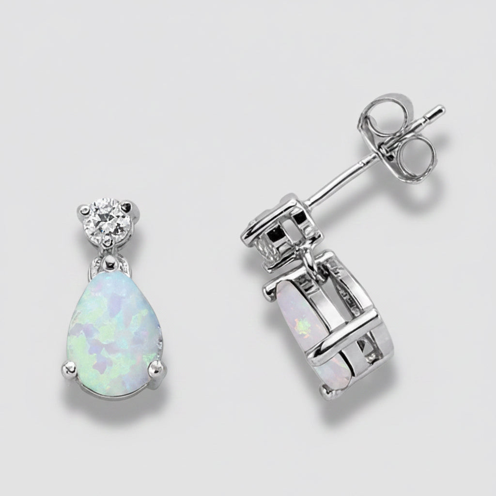 Opal teardrop earrings with silver setting on a white background