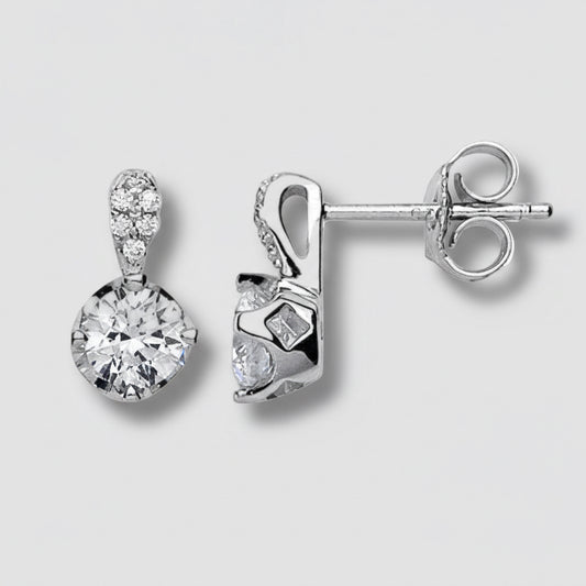 Pair of silver earrings with clear gemstones on a light gray background