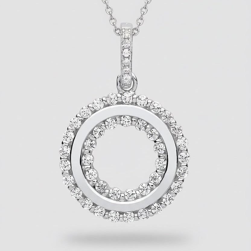 Silver pendant with circular design and embedded stones on a white background