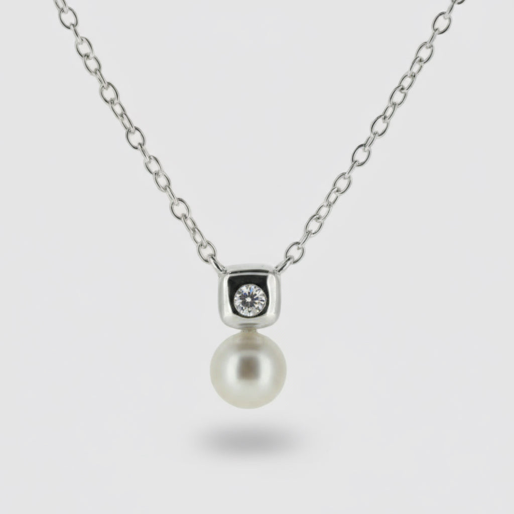 Necklace with a pearl pendant and diamond on a light gray background