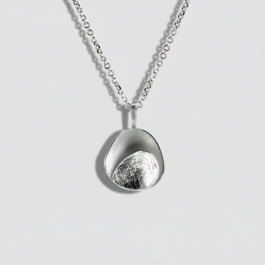 Silver necklace with a unique pendant on a light gray background