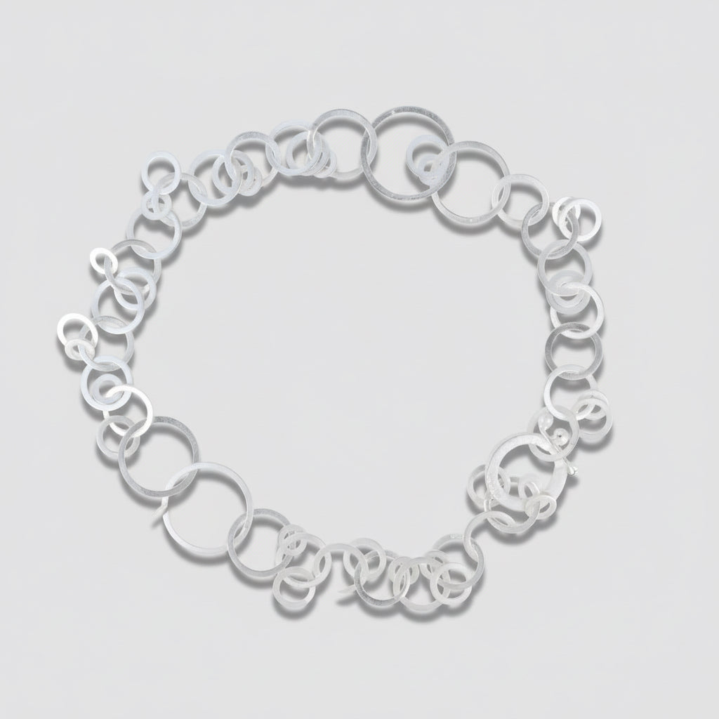 Silver necklace on a light gray background