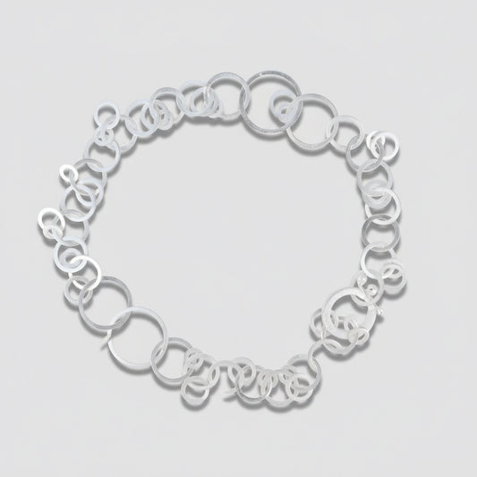 Silver necklace on a light gray background