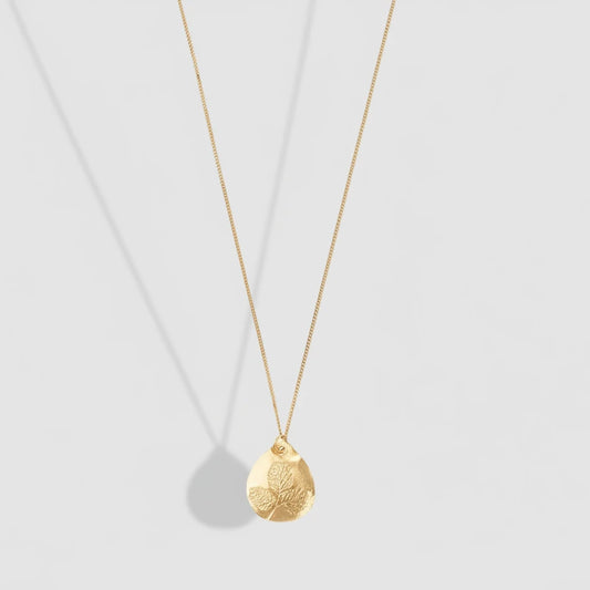 Gold necklace with a textured pendant on a white background