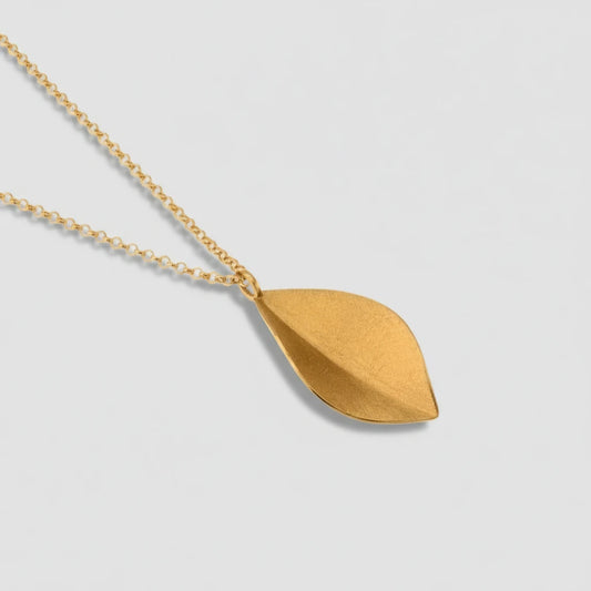 Gold necklace with a leaf-shaped pendant on a white background
