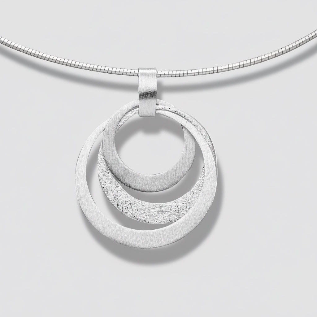 Silver necklace with a double circular pendant on a white background