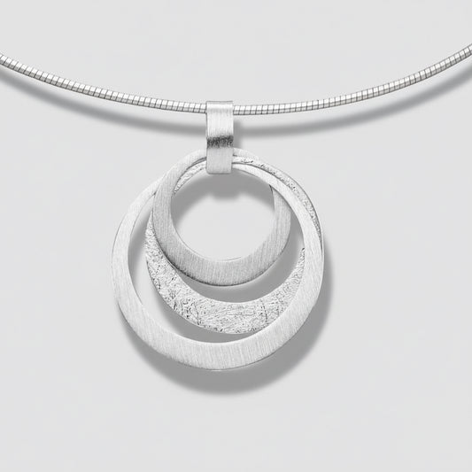 Silver necklace with a double circular pendant on a white background