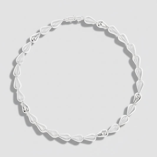 Silver necklace with marbled design on a white background