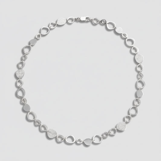 Silver bracelet with circular links on a white background