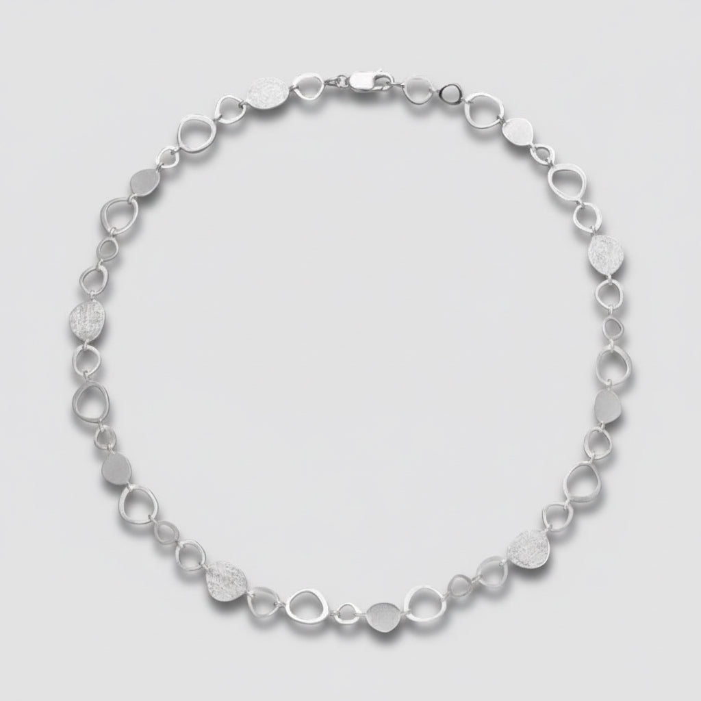 Silver bracelet with circular links on a white background