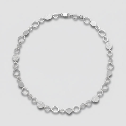 Silver bracelet with circular links on a white background