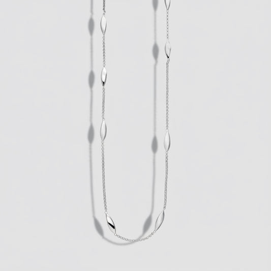 Silver necklace with small oval pendants on a white background
