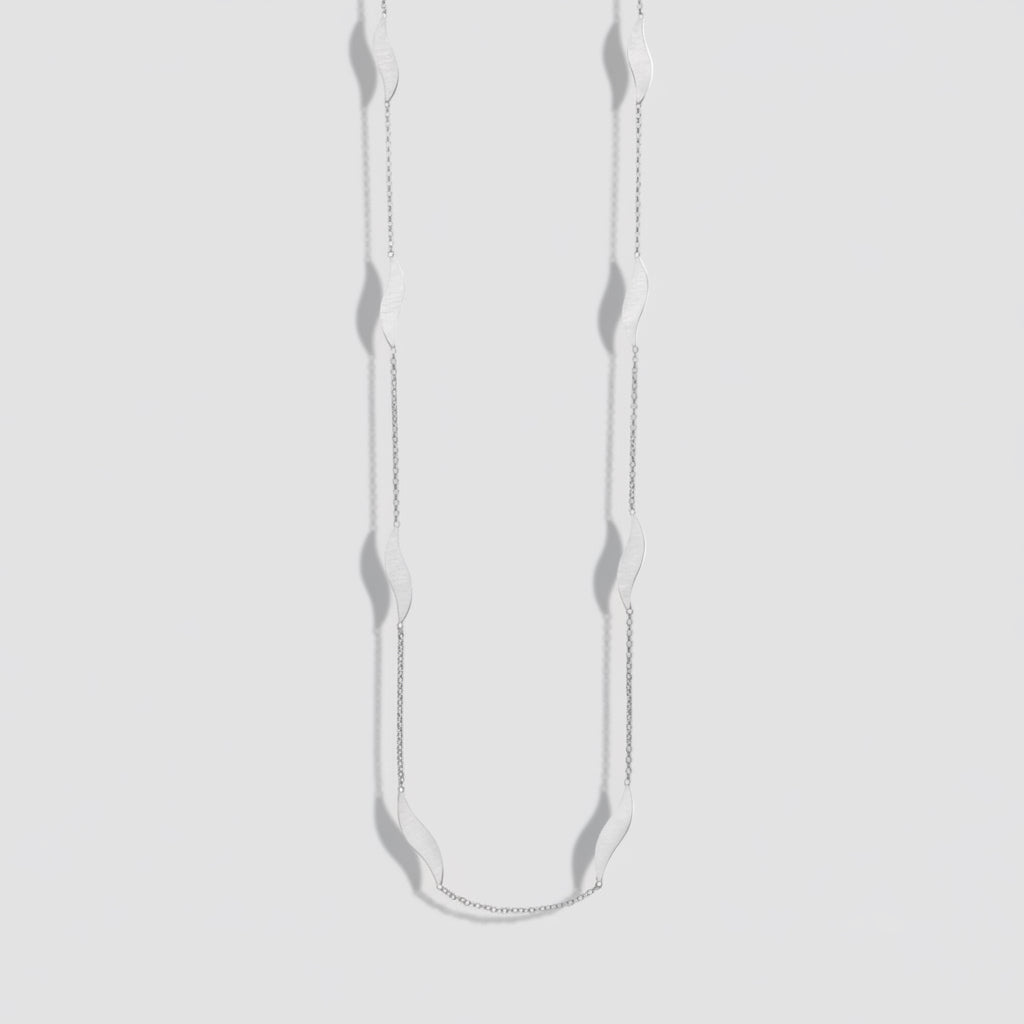 Silver necklace with small pendants on a white background