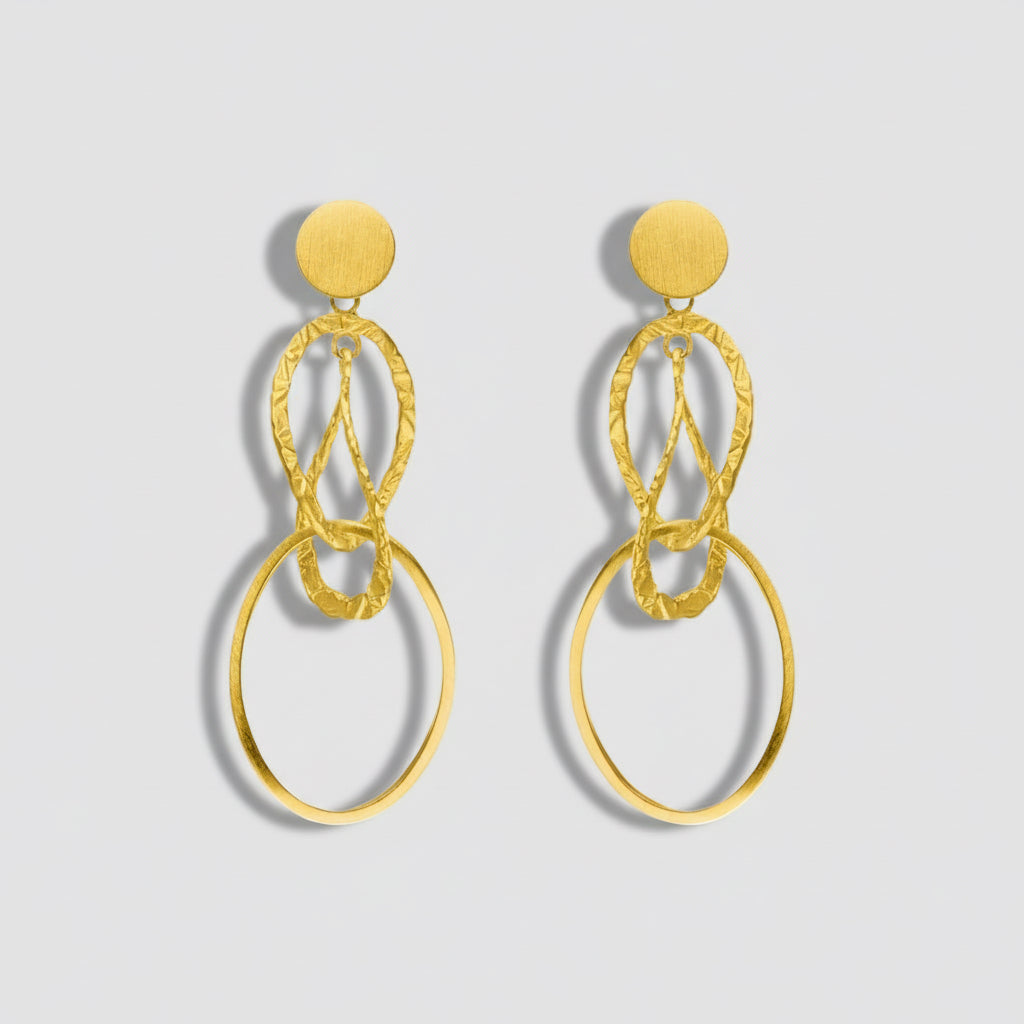 Gold earrings with circular design on a white background