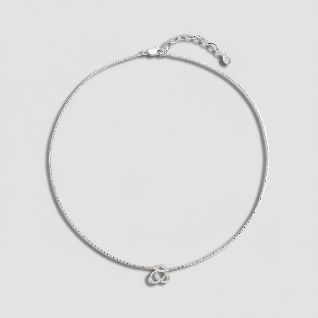 Silver necklace with a double heart pendant on a white background