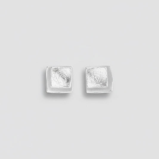 Pair of silver square stud earrings on a white background