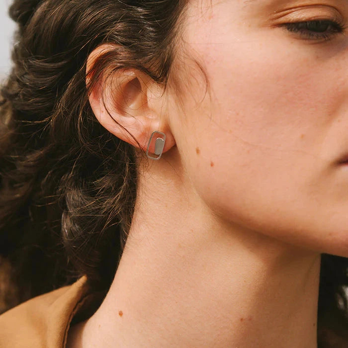 Close-up of a person wearing a small hoop earring.